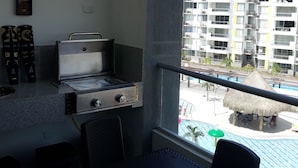 A balcony with a view of a swimming pool and high-rise buildings. - Comfort, NATURE, REST AND FUN WITH THE FAMILY (RICAURTE CUNDINAMARCA)