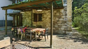 Un bâtiment en pierre doté d’un patio couvert.