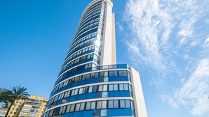 A modern high-rise building with a curved facade and numerous windows. - Acintur 13-A (Benidorm)