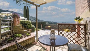 A patio with a round table, a bench, and potted plants. - Private Villa with WIFI, A/C, private pool, TV, patio, panoramic view, close to San Gimignano (Iano)