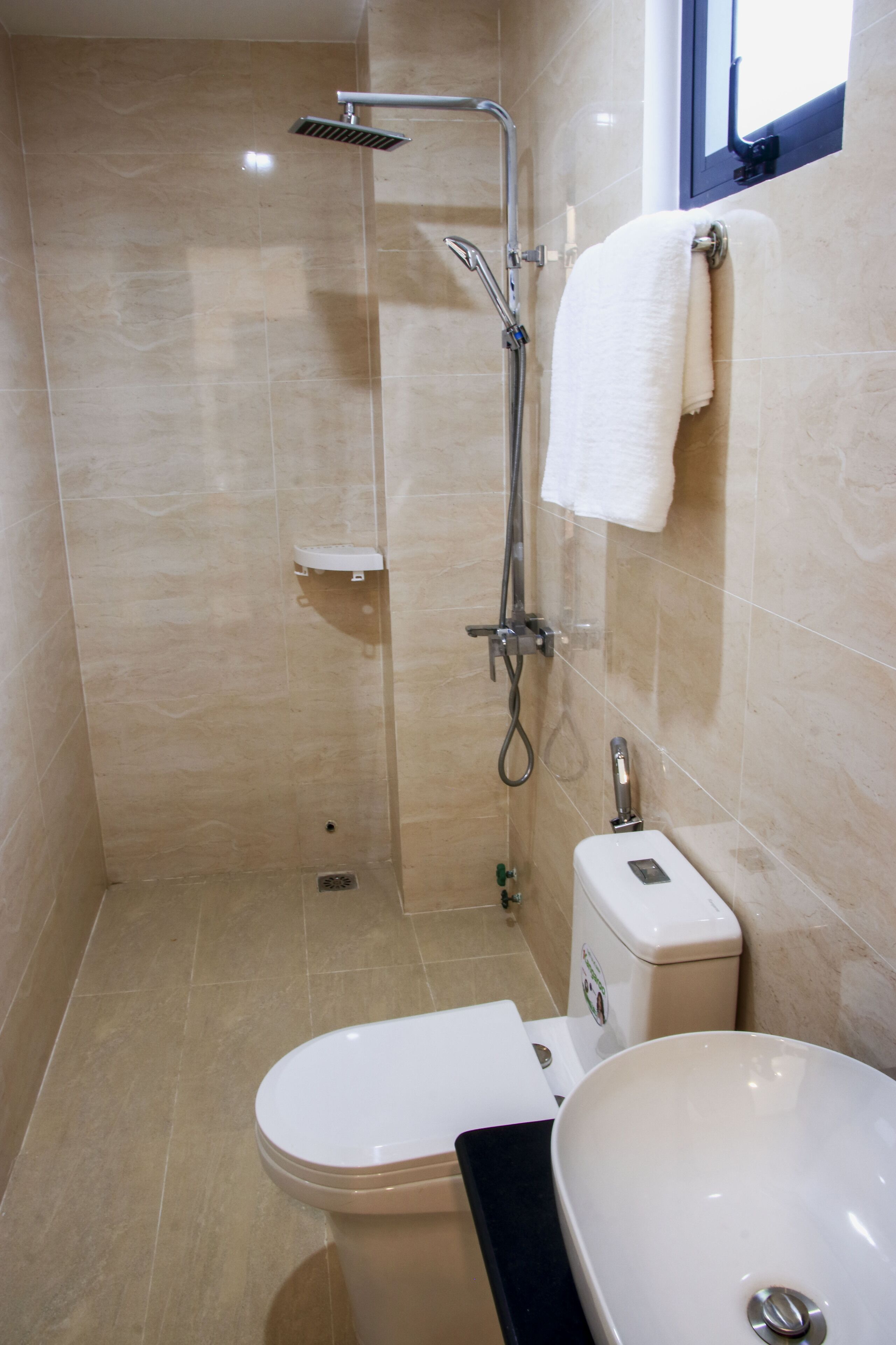 A bathroom with a shower, toilet, and sink.