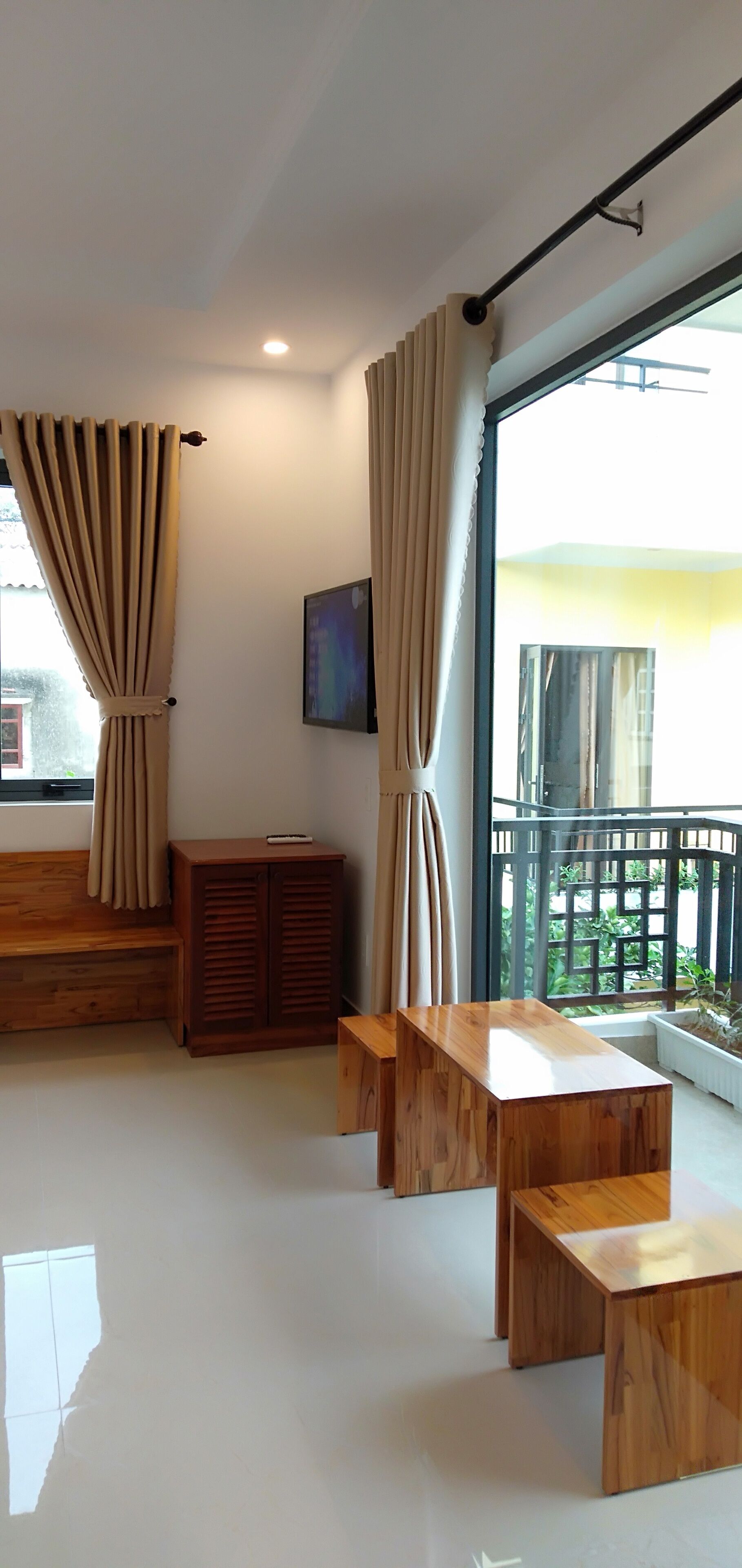 A modern room with a wooden bench, a small cabinet, and a table.