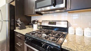 A kitchen with stainless steel appliances, granite countertops, and white storage jars. - Half a mile from everything in the heart of Evanston, Illinois (Evanston)
