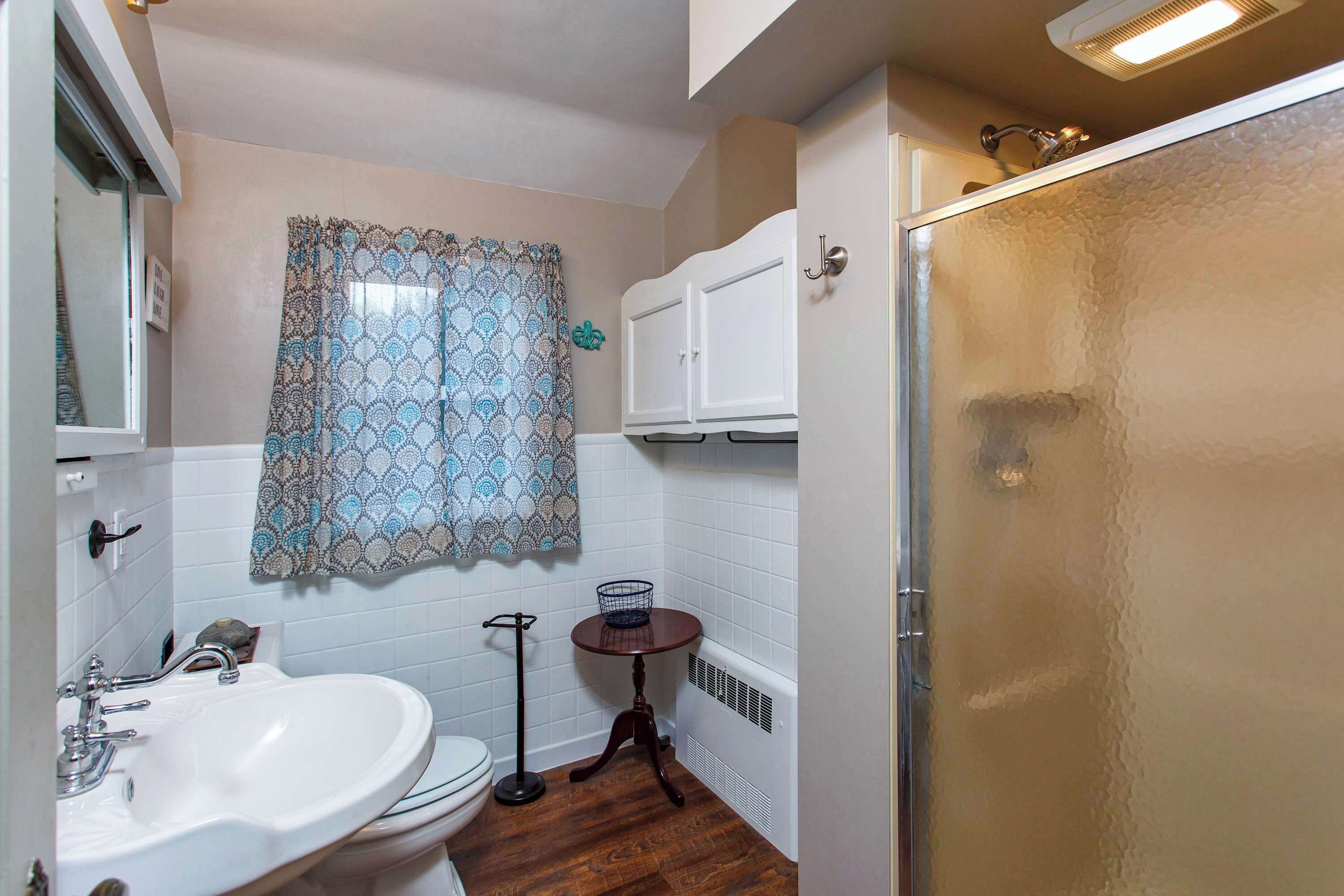 Une salle de bain avec un lavabo, des toilettes et une douche.