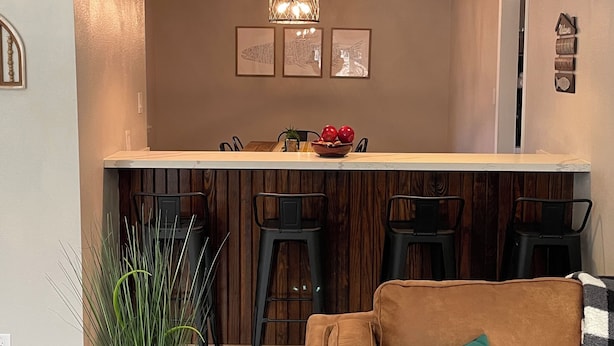 Una sala moderna con un sofá marrón, una mesa de centro y una planta en maceta.