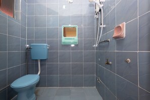 Un baño pequeño con azulejos, un inodoro, un orinal y un cabezal de ducha.