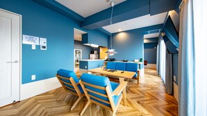Un comedor moderno con paredes azules, suelo de madera y sillas azules.