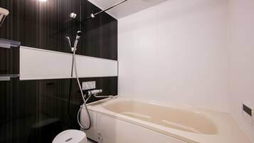 Un baño moderno con bañera, ducha e inodoro.