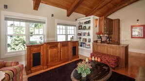A spacious living room with wooden cabinets, a fireplace, and a large window with a view of greenery.