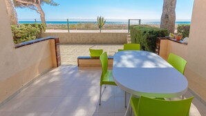 Un patio con tavolo e sedie, vista sul mare e una recinzione.