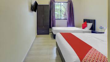 A hotel room with two beds, a wardrobe, a TV mounted on the wall, and a window with curtains.
