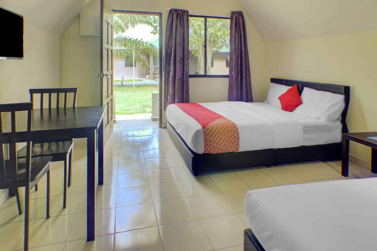 Une chambre d’hôtel avec un lit, un bureau et des chaises.