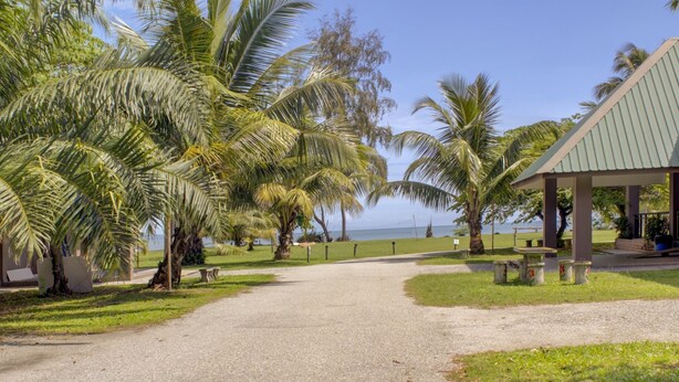 Caminho que leva a um pavilhão coberto com vista para o oceano.