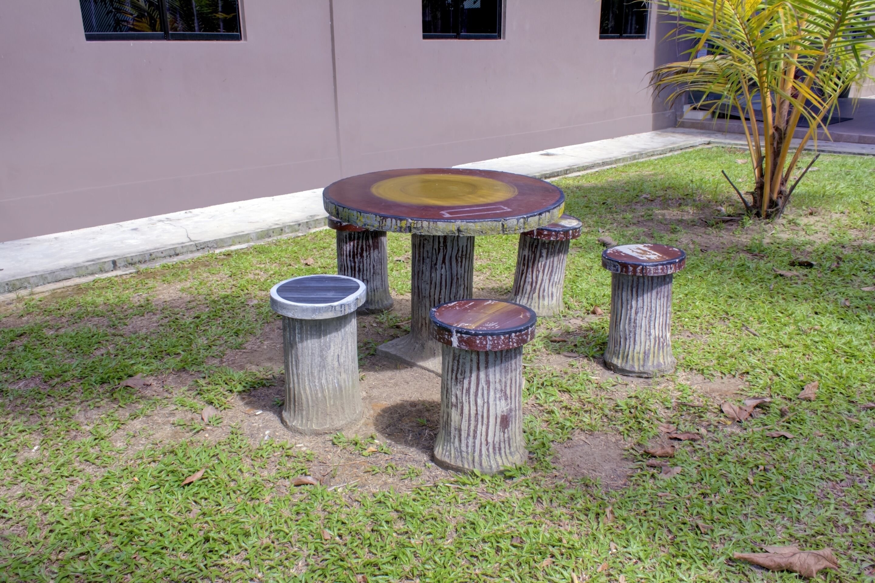 Un pequeño espacio al aire libre con una mesa redonda y cuatro taburetes.