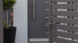 A modern building with a grey door, a potted plant, and a number sign '18' on the wall. - Holiday Home Aspalathos, 2 BDR Apt, Close To All Tourist Attractions 		 (Split)