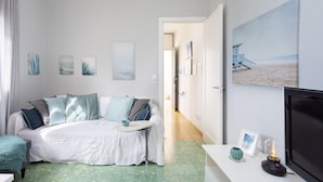 Une chambre à coucher avec un lit, une table de chevet avec une lampe et un mur orné de tableaux.