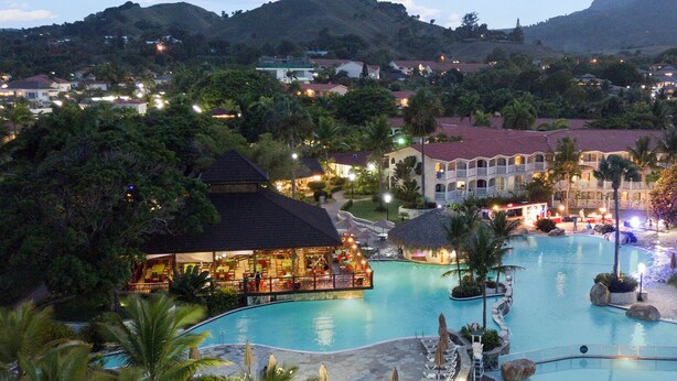 A resort with a large swimming pool, multiple buildings, and lush greenery. - Soak up sun & fun at a 6-bed villa in the Dominican Republic resort on the ocean (Cofresi)
