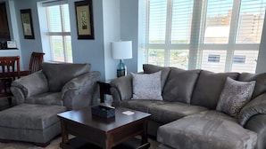 A living room with a sectional sofa, a coffee table, and a rug.