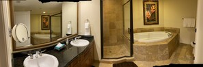 A bathroom with two sinks, a large mirror, a shower enclosure, and a bathtub.