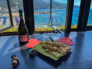 Une table avec une bouteille de vin, deux verres et une assiette de pain.