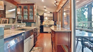 A modern kitchen with a dishwasher, stove, and cabinets. - House in the Woods [whole house] (Issaquah)