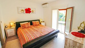 A bedroom with a bed, bedside tables, a nightstand, a mirror, and a view of the outdoors. - Judith - modern apartment in Moraira (Moraira)