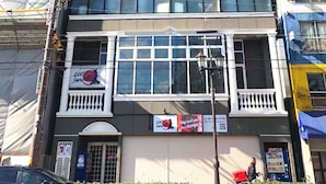 Un edificio de varios pisos con una serie de balcones y grandes ventanales.
