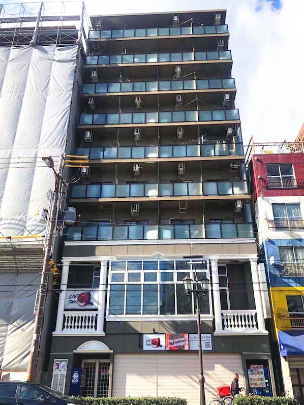 A multi-story building with a series of balconies and large windows.