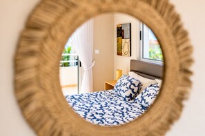 A bedroom with a bed, a nightstand, a lamp, and a window with curtains.