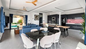 Eine moderne Küche mit schwarzen Schränken, einem Holztisch und einem blauen Sofa.