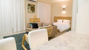 Une chambre d’hôtel avec un lit, un canapé, un bureau et une chaise.