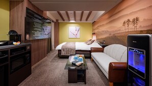 A hotel room with a bed, a sofa, a coffee table, a TV, and a wall with a scenic mural. - HOTEL WILL BASE Tsurumi - Adults Only (Yokohama)