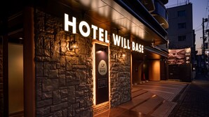 A hotel entrance with a stone facade and illuminated signage. - HOTEL WILL BASE Tsurumi - Adults Only (Yokohama)