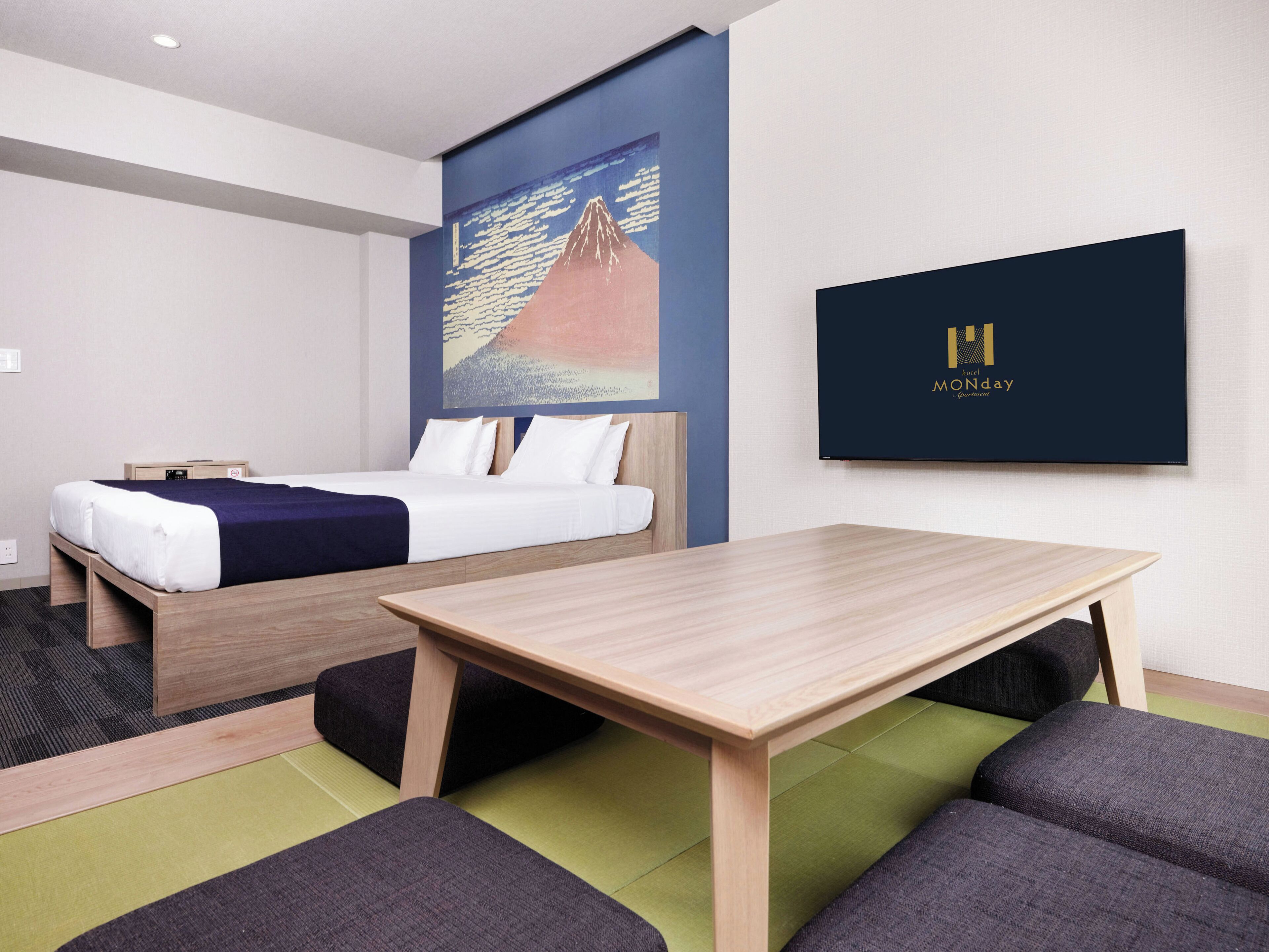A hotel room with a bed, a desk, and a chair.