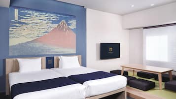 A hotel room with a bed, a desk, and a wall-mounted TV.
