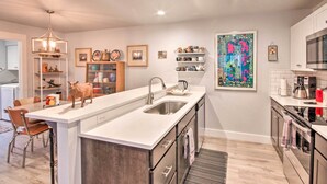 A modern kitchen with a central island, stainless steel appliances, and a variety of decorative items. - Quiet Home by Dtwn Livingston: Hike, Fish & Ski! (Livingston)