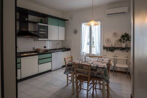A kitchen with a dining table, chairs, and a hanging light fixture.
