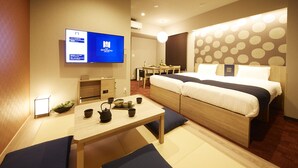 Una habitación de hotel moderna con una cama, un escritorio, un televisor y una zona de comedor.