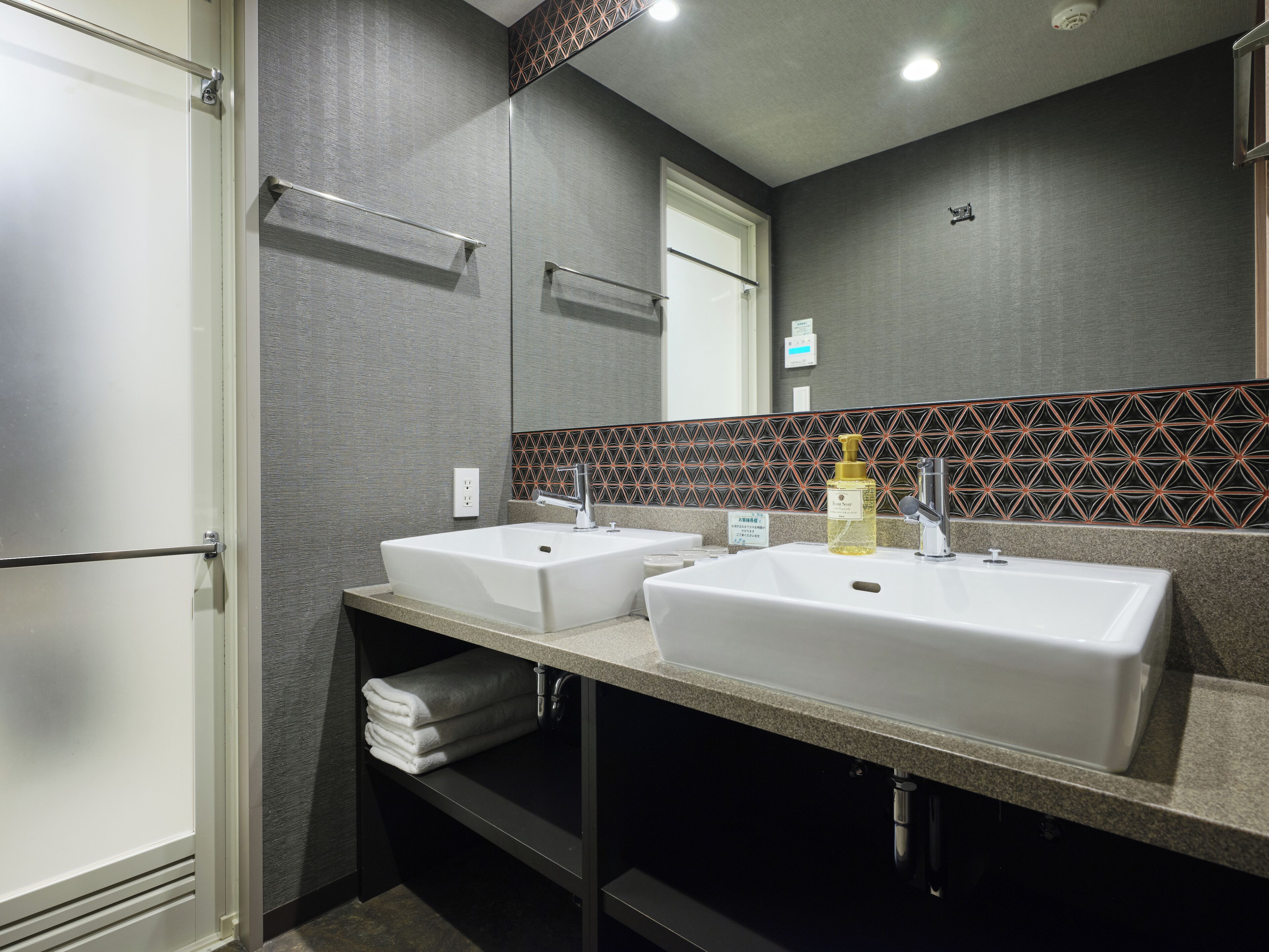 Une salle de bain moderne avec deux lavabos, un porte-serviettes et un miroir.