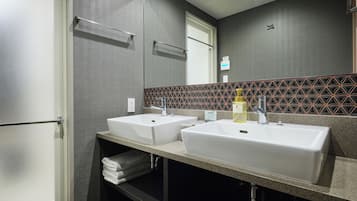 Un bagno moderno con due lavabi, un portasciuga e uno specchio.
