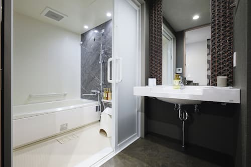 Habitación (Universal King) | Baño | Tina y regadera independientes y amenidades de baño gratuitas