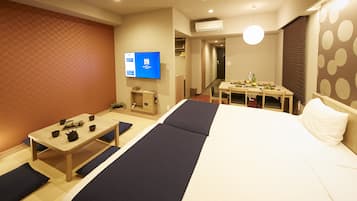 A hotel room with a bed, a desk, and a television.