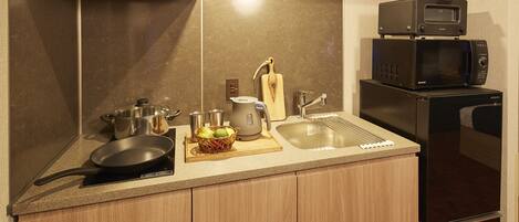 Una cocina con microondas, estufa, fregadero y armarios de madera.