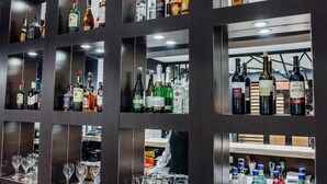 A bar area with multiple shelves of liquor bottles and glasses. - Express City Hotel (Shymkent)