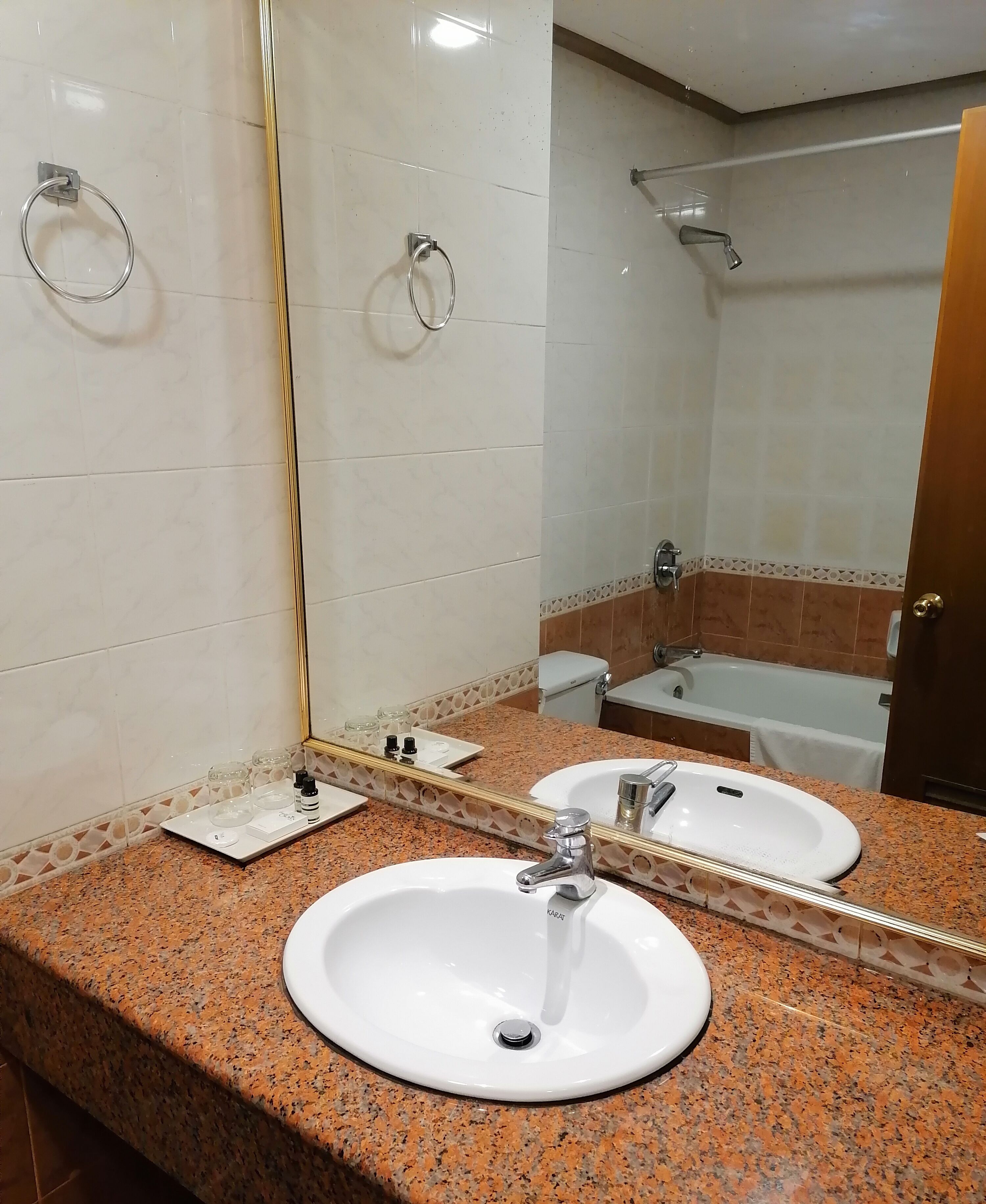 A bathroom with two sinks, a shower, and a mirror.