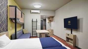 Une chambre d’hôtel avec deux lits, un bureau, une télévision et une armoire.