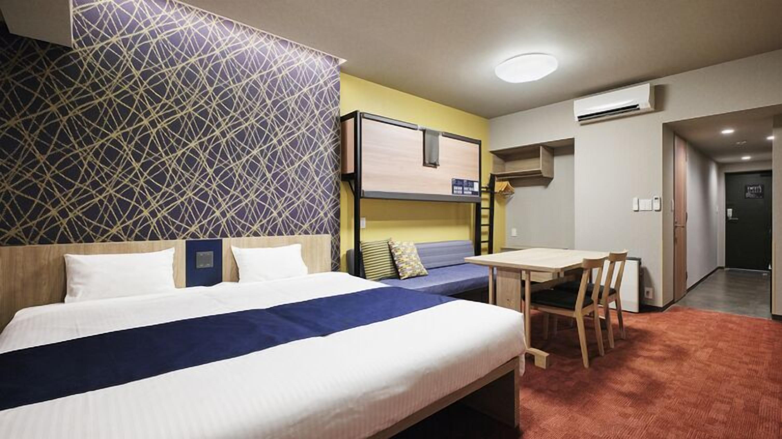 A hotel room with a bed, a desk, and a chair.