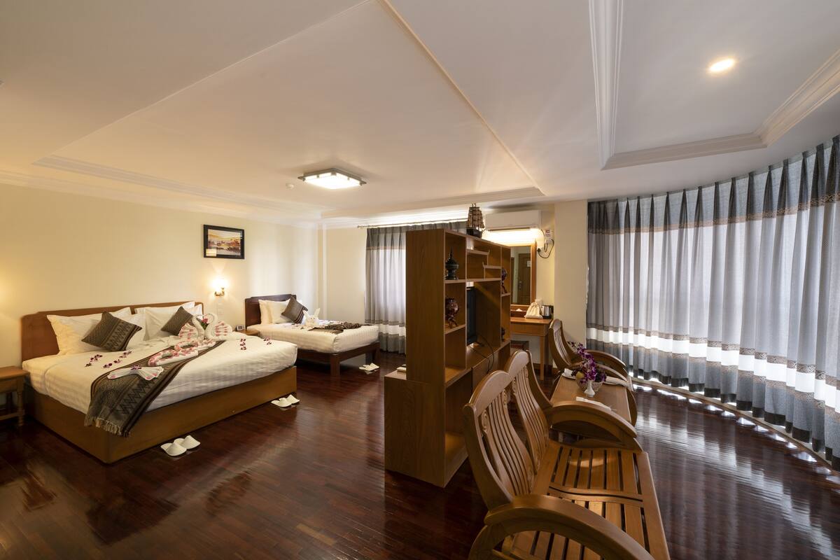 Quarto de hotel com uma cama, uma escrivaninha e um espaço de estar.