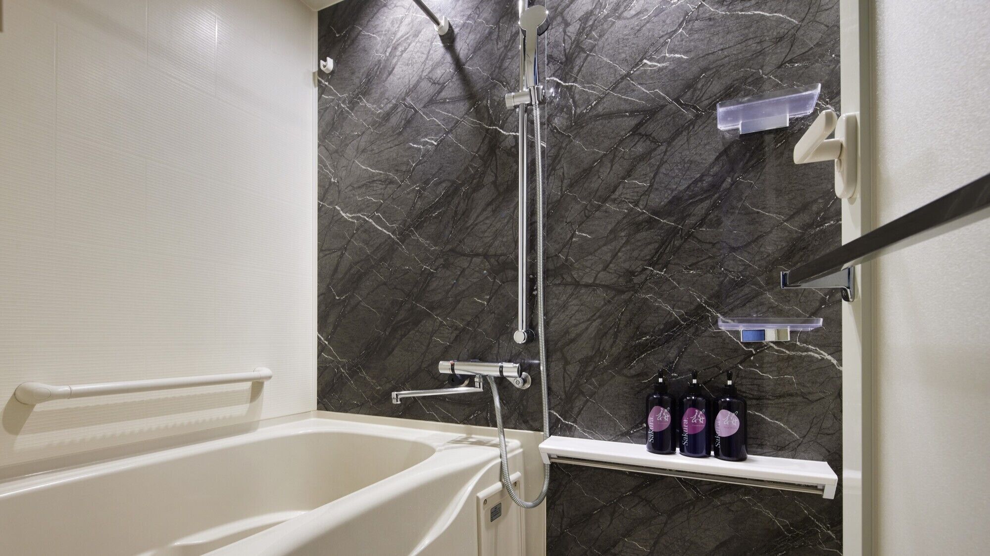 Une salle de bain avec une baignoire, une douche et une étagère remplie de bouteilles.
