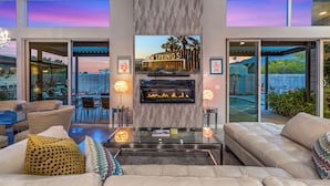 Ein modernes Wohnzimmer mit Kamin, bequemen Sitzgelegenheiten und Blick auf Palm Springs.